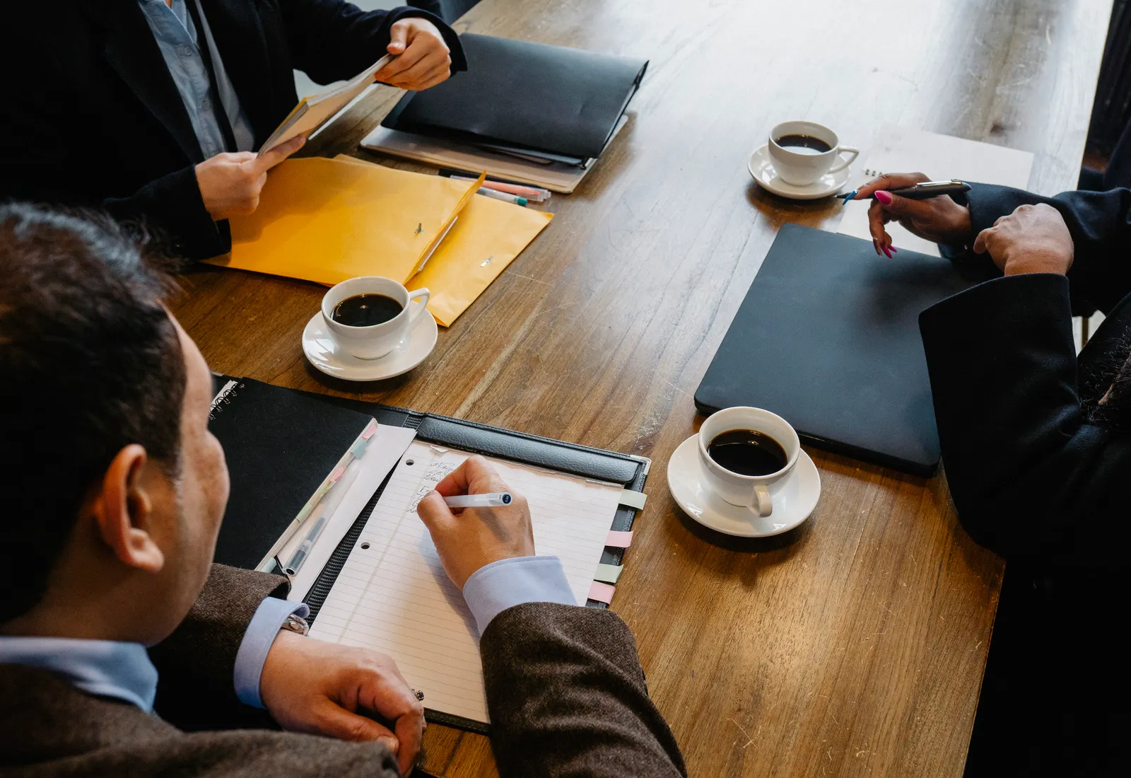 Reunión de asesoramiento con documentación y café sobre la mesa